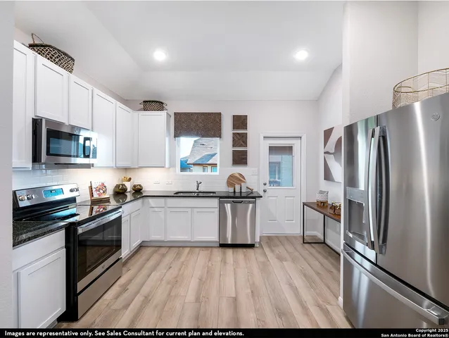 a kitchen with granite countertop a refrigerator stove top oven and sink