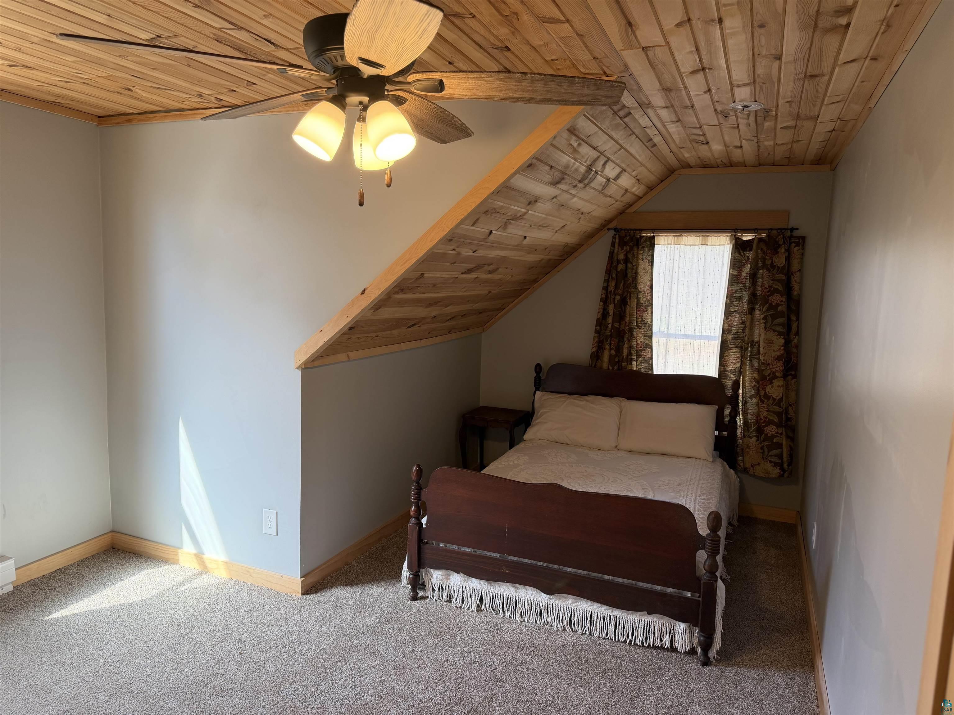 5274 Marble Lake Road Two Harbors, MN 55616 - Photo 42 of 79 Room featuring a wood-panel sloped ceiling, light gray wall paint, and a ceiling fan with integrated lighting