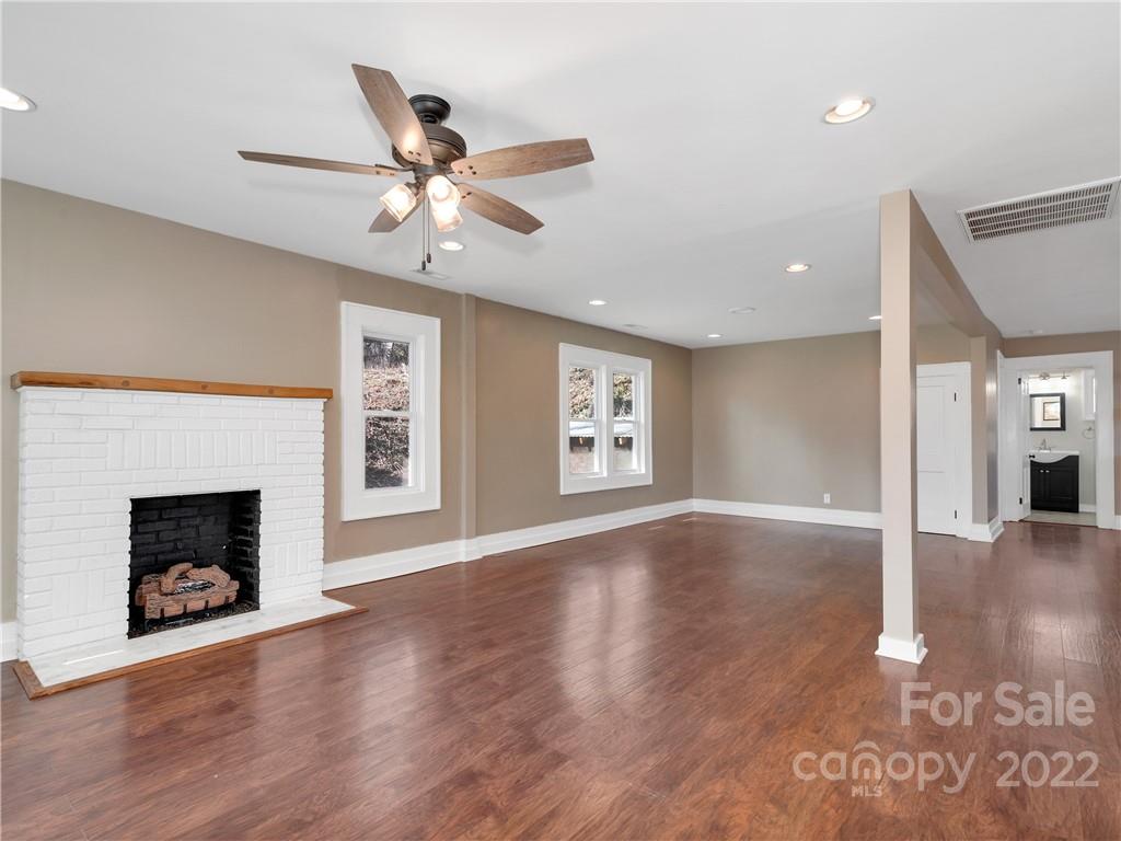 1739 Old Clyde Road Clyde, NC 28721 - Photo 8 of 24 a view of an empty room with wooden floor fireplace and a window