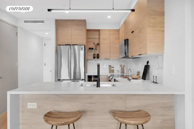 a kitchen with a refrigerator a stove top oven a sink dishwasher and a refrigerator with wooden floor