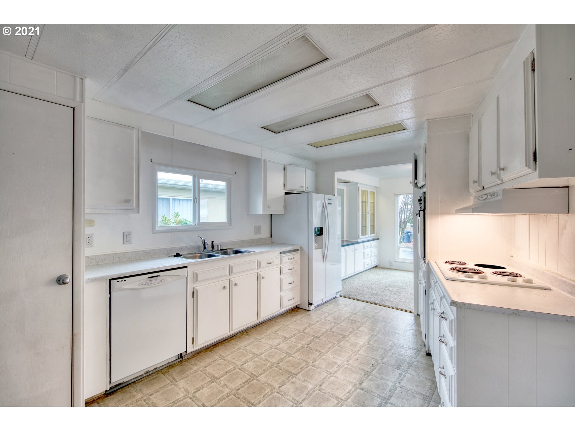 3530 Game Farm Road, Unit 46 Springfield, OR 97477 - Photo 15 of 32 a large white kitchen with stainless steel appliances kitchen island granite countertop a sink and cabinets