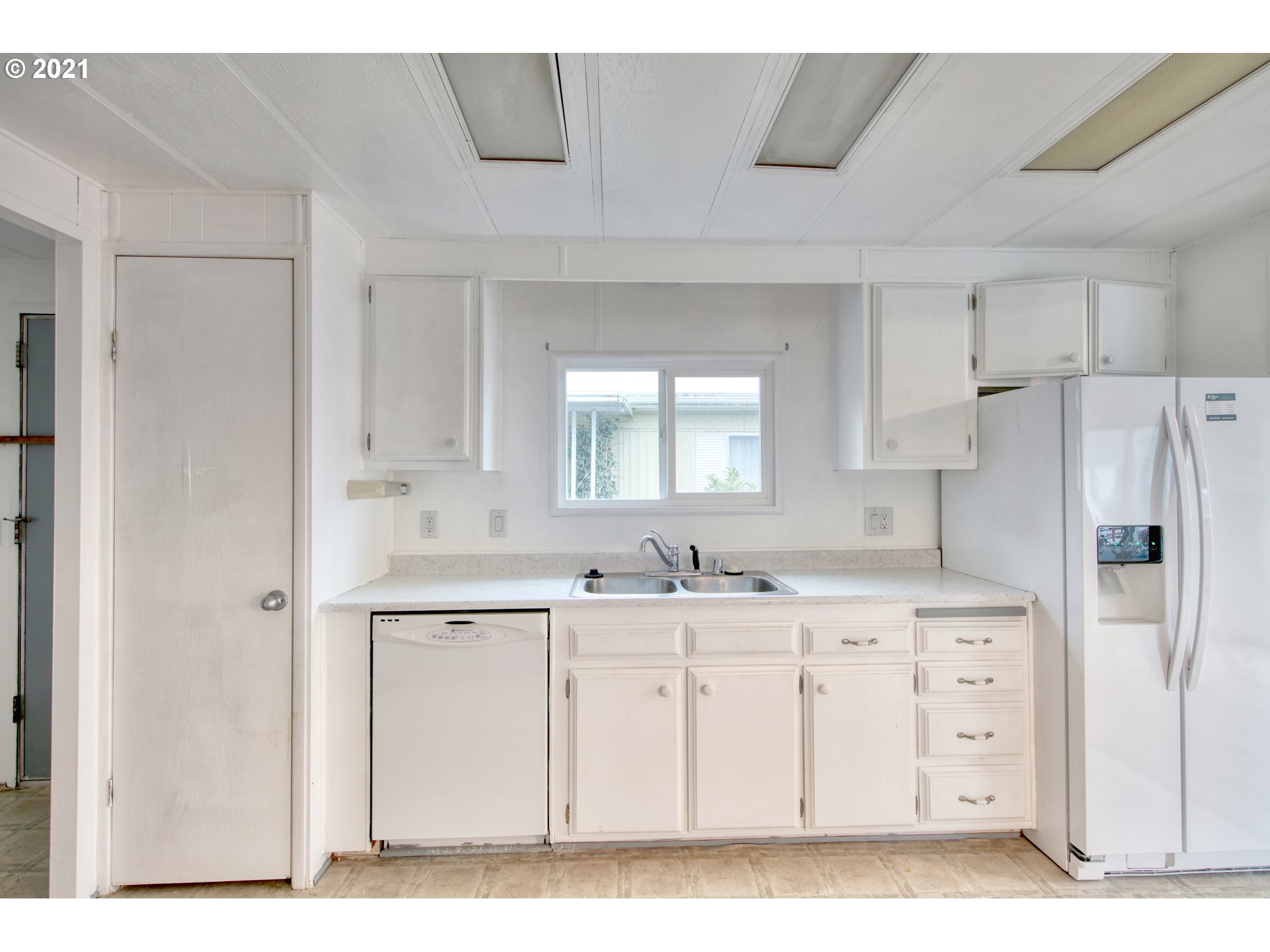 3530 Game Farm Road, Unit 46 Springfield, OR 97477 - Photo 18 of 32 a kitchen with a sink a refrigerator a window and white cabinets