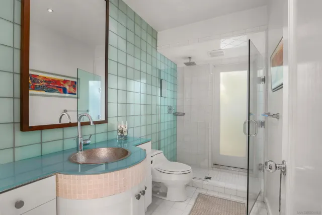 a bathroom with a sink toilet a mirror and shower