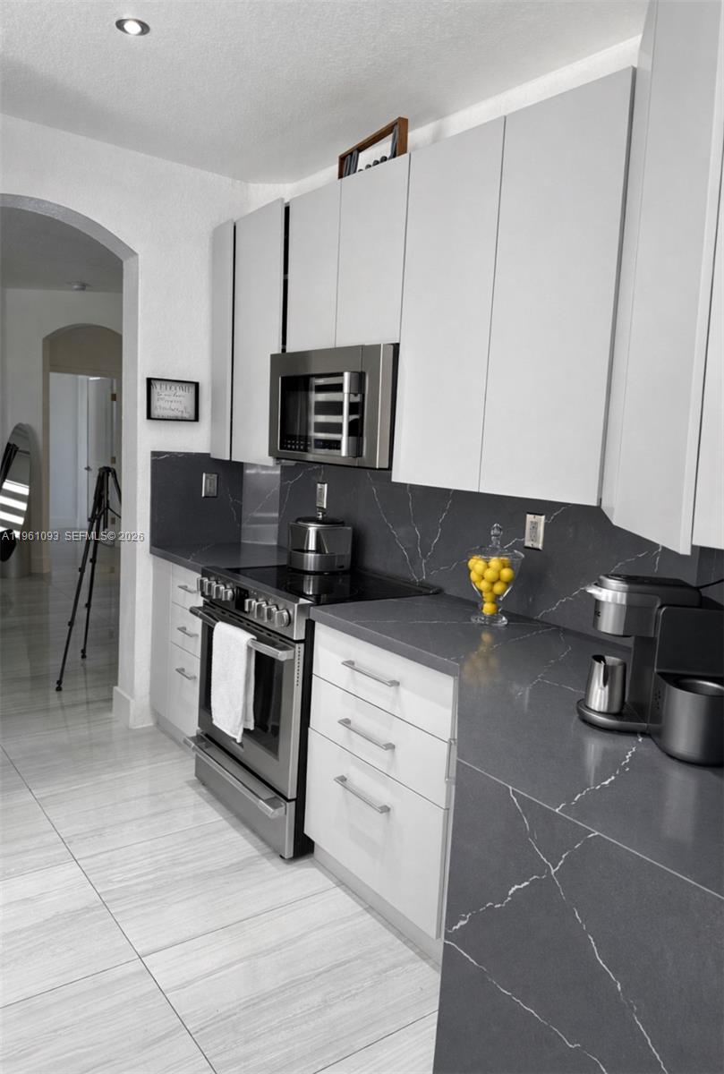 14214 Southwest 289th Terrace Homestead, FL 33033 - Photo 6 of 13 a kitchen with stainless steel appliances a stove a refrigerator a sink a counter space and cabinets