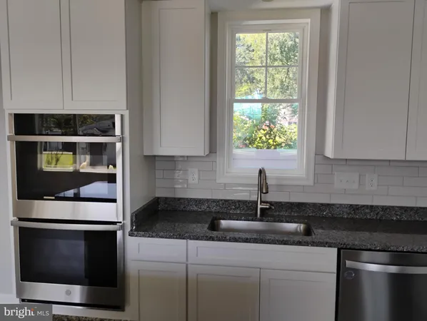 a kitchen with appliances a sink and cabinets