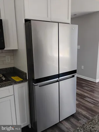 a white refrigerator freezer and a stove sitting inside of a kitchen