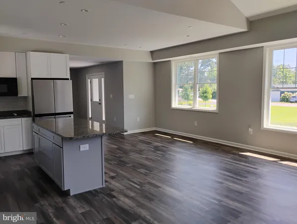a kitchen with granite countertop wooden floors and wide window