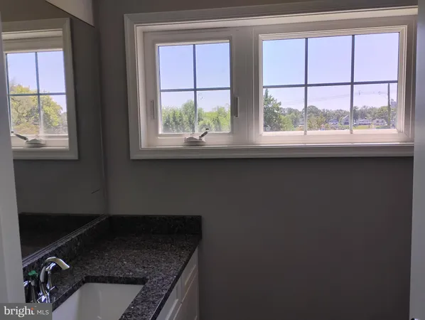 a bathroom with a sink a window and a mirror