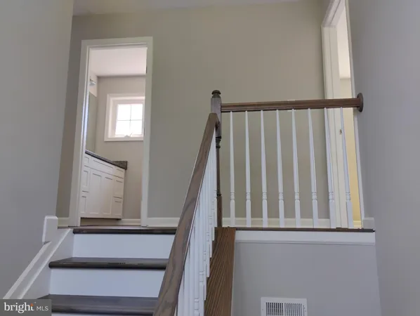 a view of staircase with railing and white walls