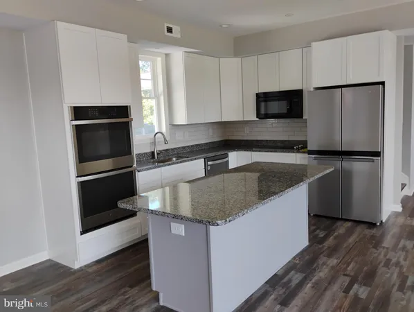 a kitchen with granite countertop a sink stove and refrigerator
