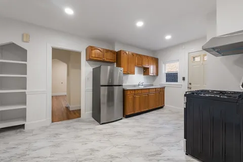 a kitchen with stainless steel appliances granite countertop a refrigerator a sink and a stove