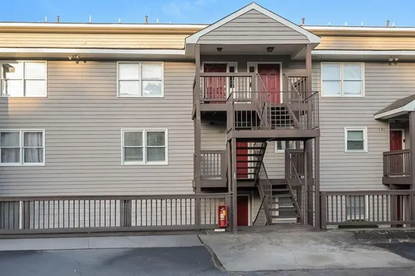 a view of a house with wooden fence and a large window