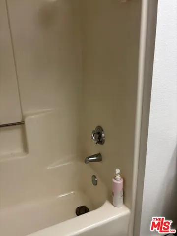 a bath tub sitting next to a white sink and vanity