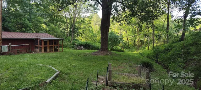 a view of a dry yard with wooden fence
