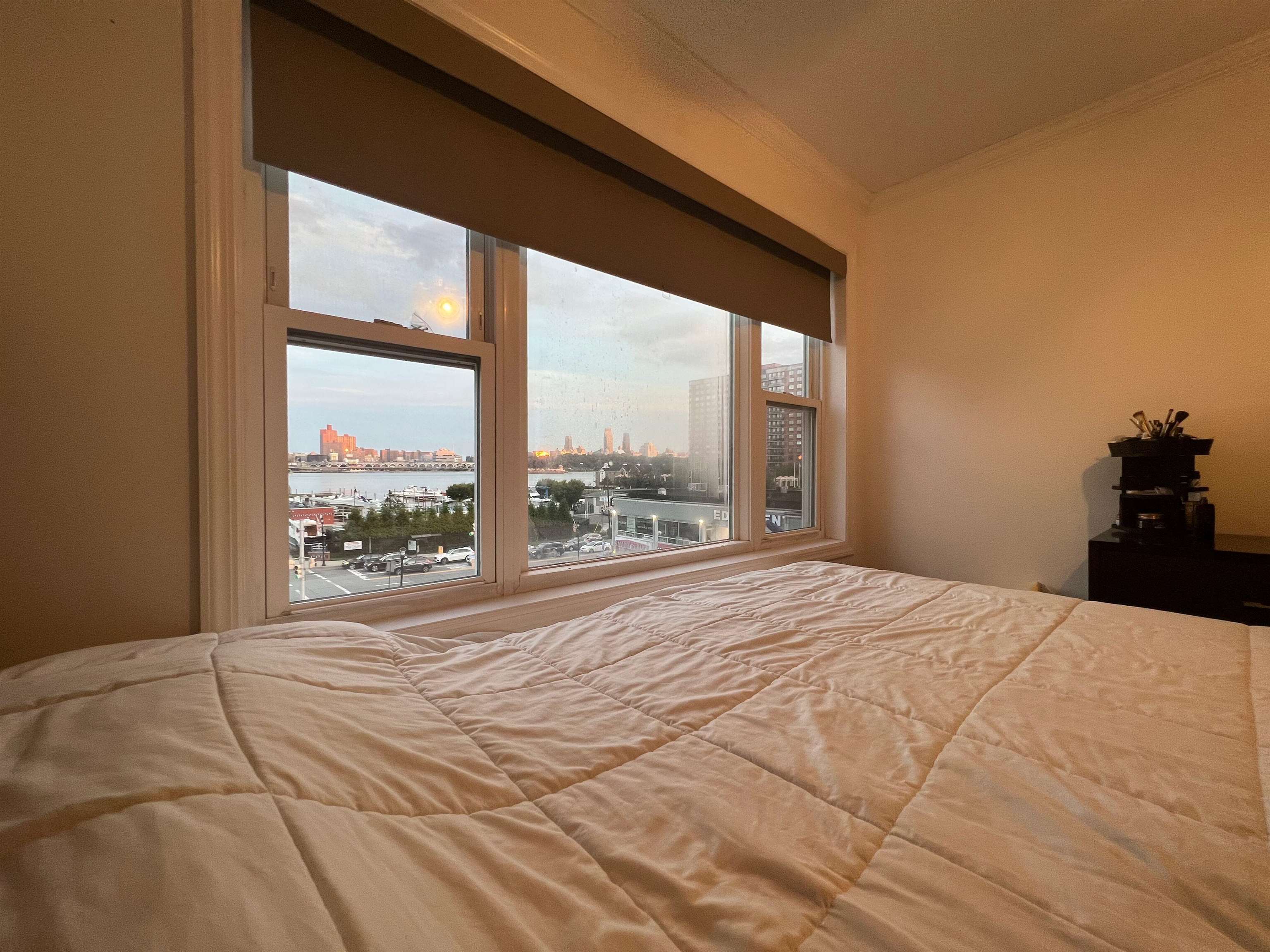 a large bedroom with a bed and a large window
