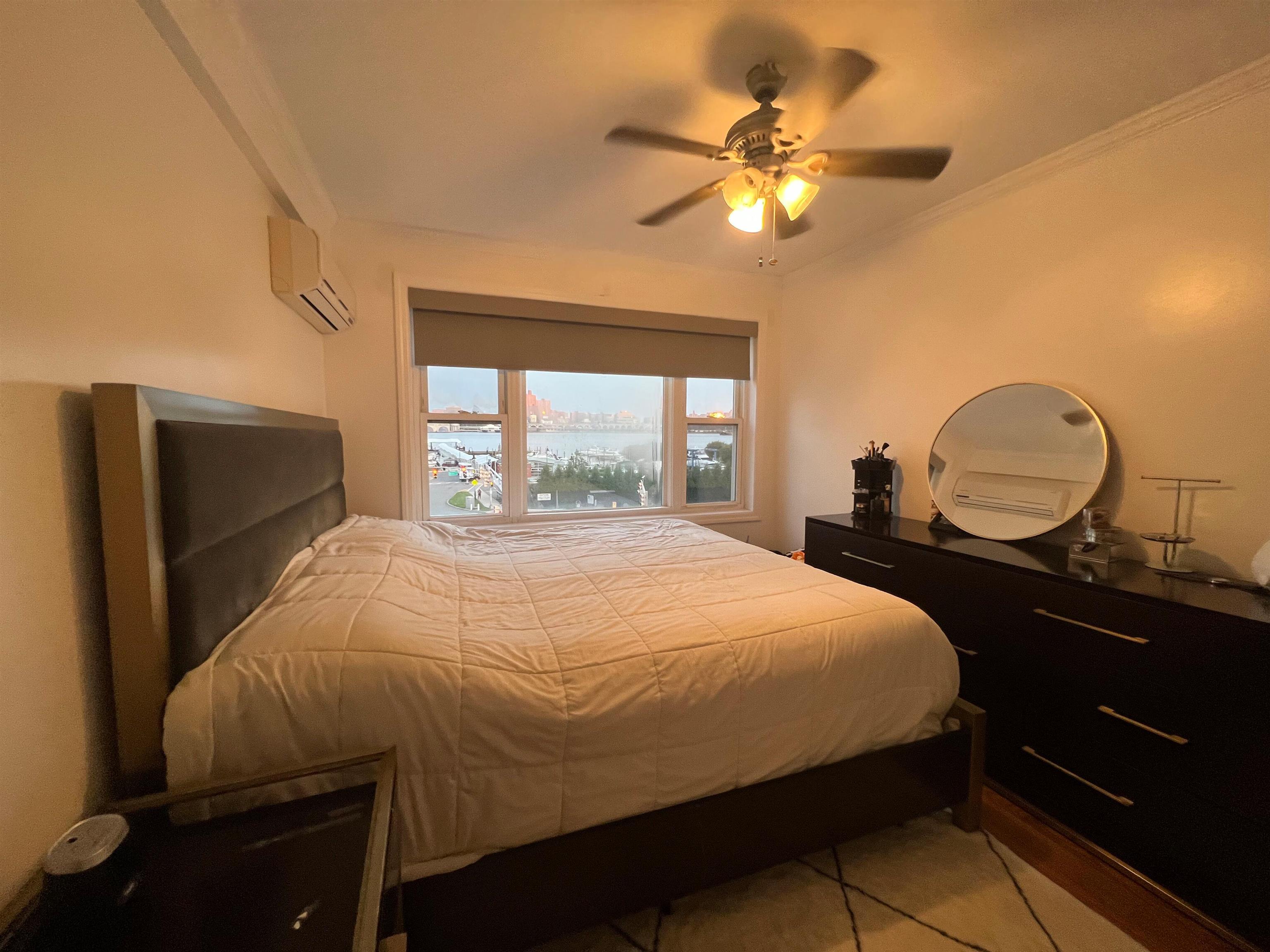 11 Beverly Place, Unit 1 Edgewater, NJ 07020 - Photo 2 of 18 a bedroom with a bed and a chandelier