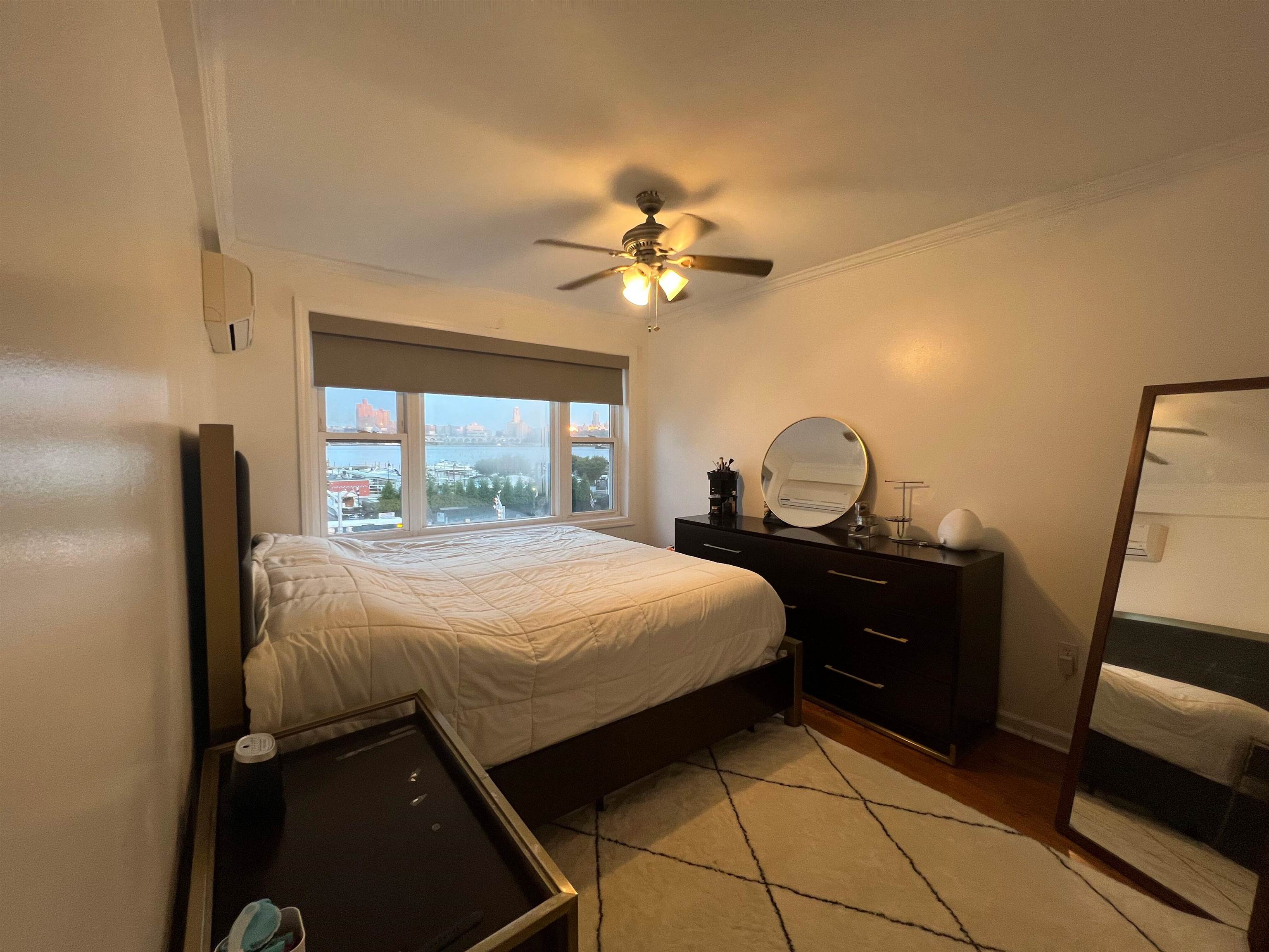 11 Beverly Place, Unit 1 Edgewater, NJ 07020 - Photo 3 of 18 a bedroom with a bed and a mirror