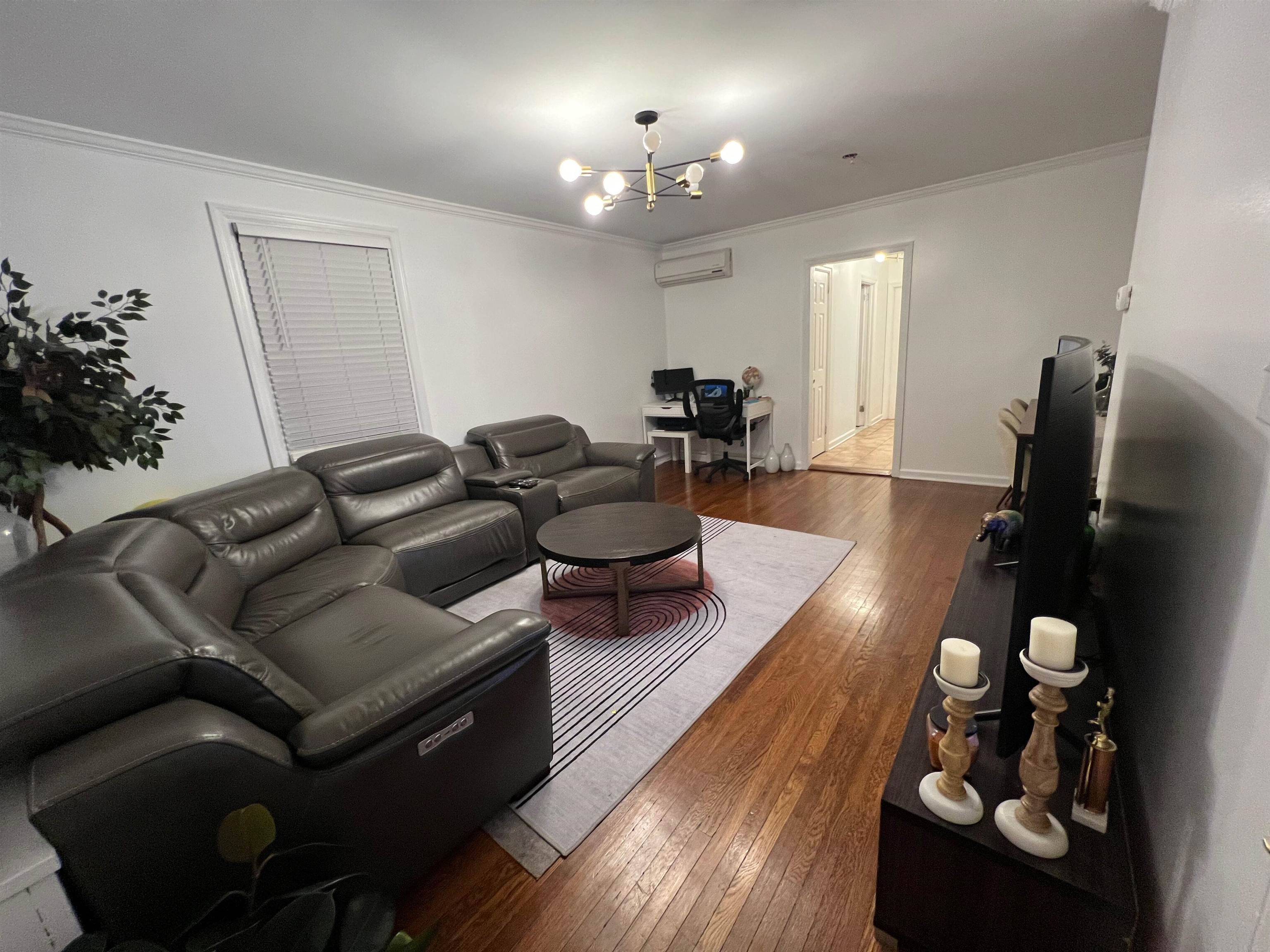 11 Beverly Place, Unit 1 Edgewater, NJ 07020 - Photo 8 of 18 a living room with furniture and a chandelier