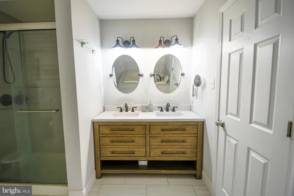 a bathroom with a double vanity sink and mirror