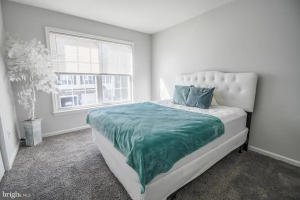 a bed sitting in a bedroom next to a window