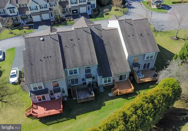 an aerial view of a swimming pool with a yard and plants