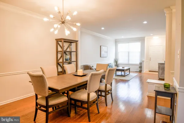 a view of a dining room with furniture a chandelier and wooden floor