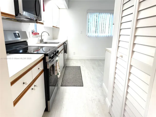 a kitchen with stainless steel appliances granite countertop a sink stove and a refrigerator