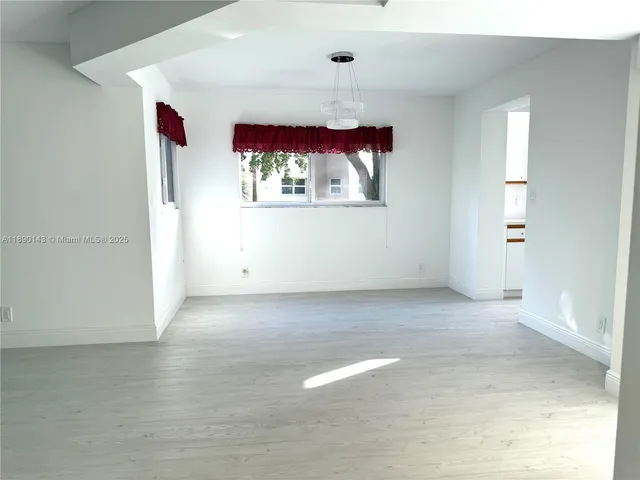 a view of a hallway with wooden floor and entryway