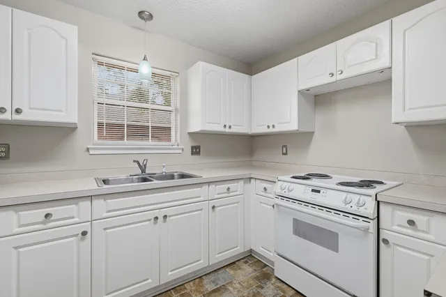 a kitchen with cabinets appliances a sink and a window