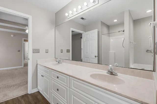 a bathroom with a sink a mirror a toilet and shower