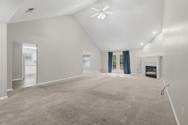 an empty room with windows and fireplace