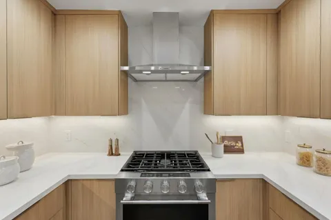 a kitchen with granite countertop a sink stove and cabinets
