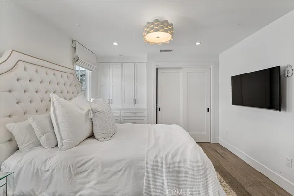 a spacious bedroom with a bed and a flat screen tv