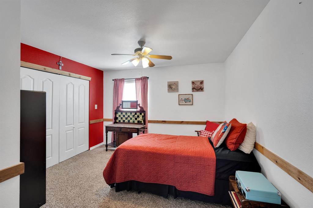 130 Eubanks Road Maypearl, TX 76064 - Photo 11 of 39 a bedroom with a bed and a chandelier