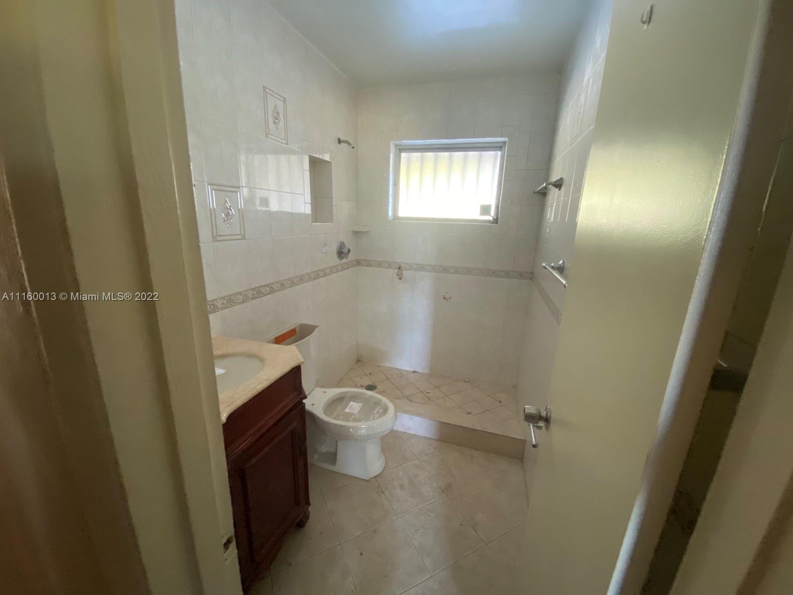 11755 Southwest 37th Street Miami, FL 33175 - Photo 5 of 11 a bathroom with a granite countertop toilet and a shower