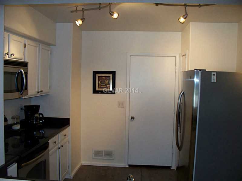 7255 West Sunset Road, Unit 2144 Las Vegas, NV 89113 - Photo 11 of 19 Kitchen. Very spacious kitchen all appliances included. Behind the door is the laundry room with a washer dryer and storage shelf