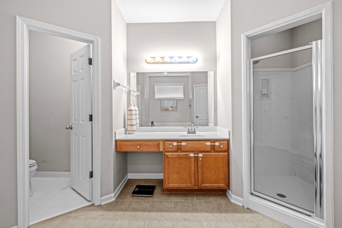 4840 Rainy Pass Road Collierville, TN 38017 - Photo 23 of 30 Bathroom vanity featuring wood cabinetry, white countertop, and a mirrored wall