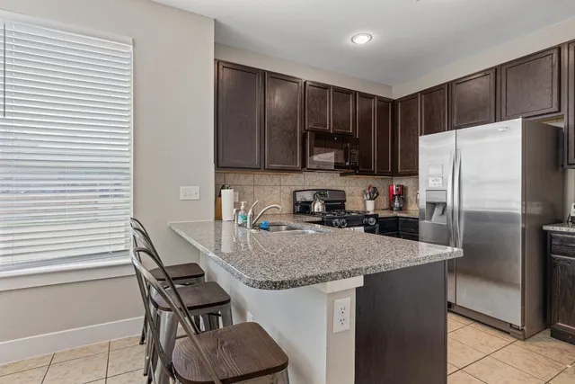a kitchen with stainless steel appliances granite countertop a sink refrigerator and microwave