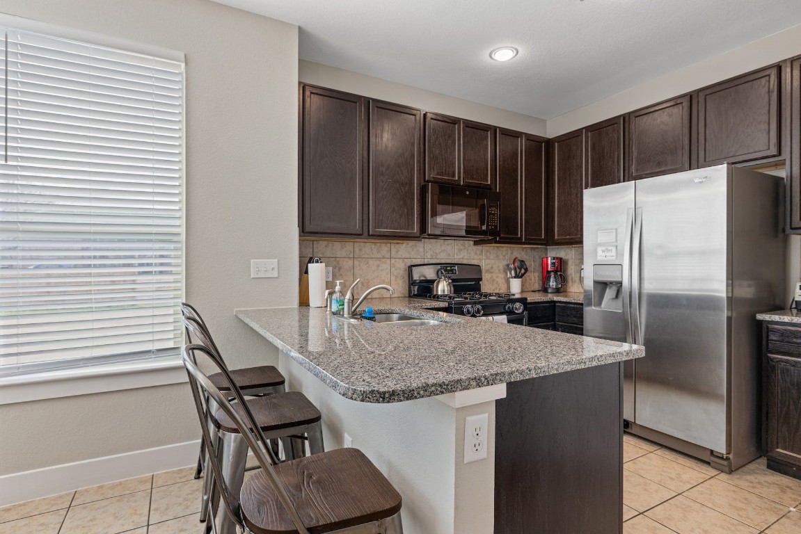 2215 Katy Lane, Unit C Georgetown, TX 78626 - Photo 13 of 26 a kitchen with stainless steel appliances granite countertop a sink refrigerator and microwave