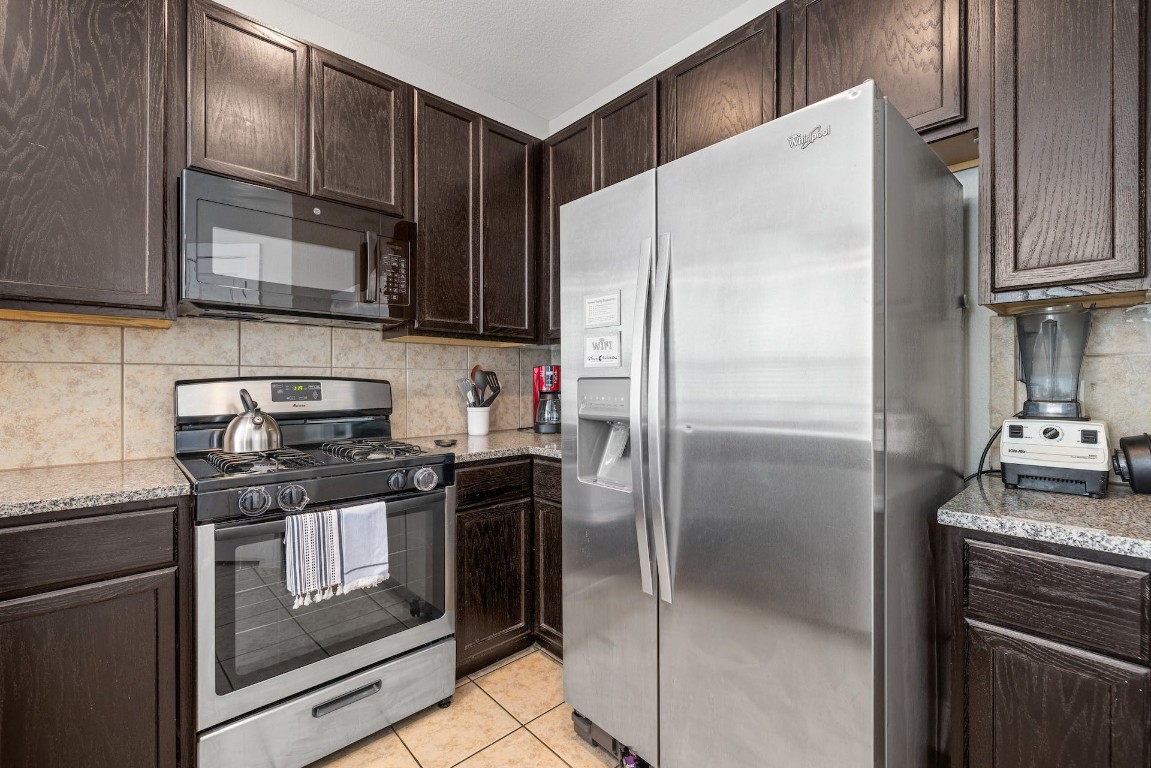 2215 Katy Lane, Unit C Georgetown, TX 78626 - Photo 14 of 26 a kitchen with granite countertop a refrigerator stove and microwave
