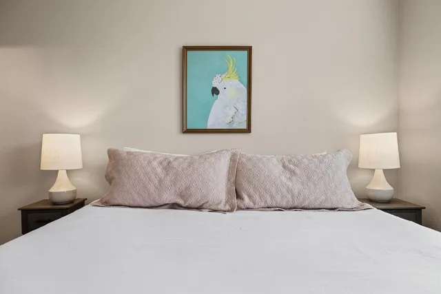 a large bed sitting in a bedroom with a lamp