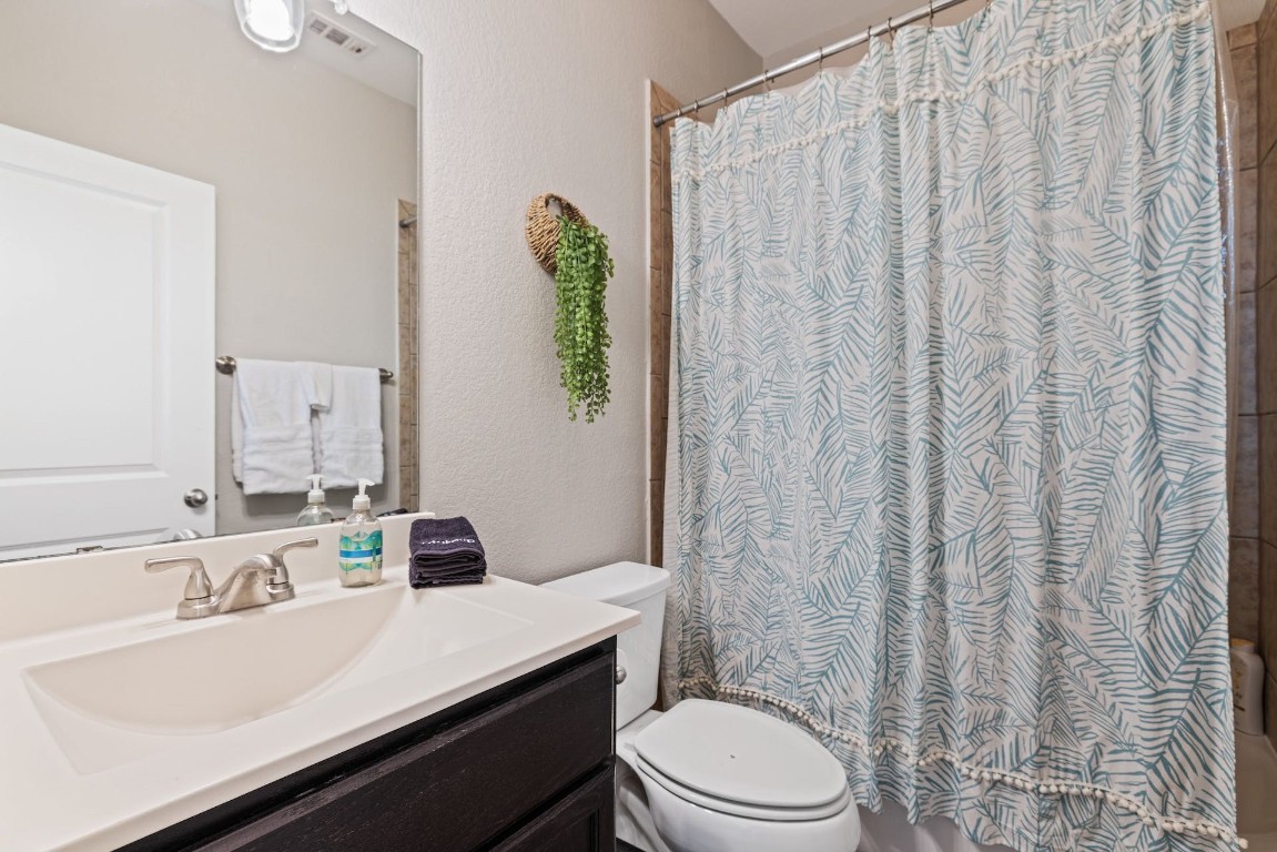 2215 Katy Lane, Unit C Georgetown, TX 78626 - Photo 21 of 26 a bathroom with a sink a toilet and shower curtain