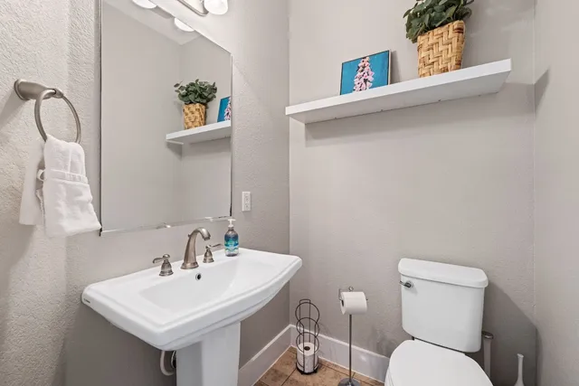a bathroom with a toilet sink and mirror