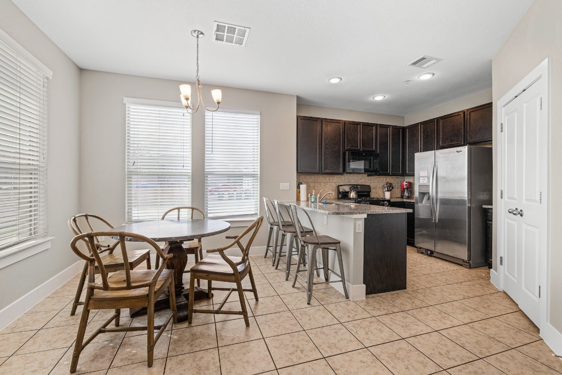 2215 Katy Lane, Unit C Georgetown, TX 78626 - Photo 8 of 26 a kitchen with granite countertop a refrigerator a stove a sink a dining table and chairs