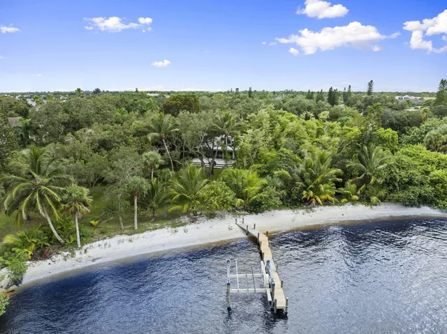 a large kitchen with stainless steel appliances granite countertop a stove and a view of living room