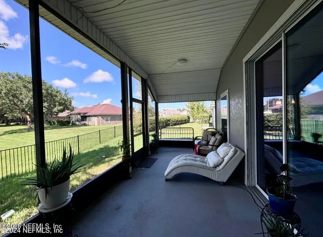 a living room with patio furniture and garden view