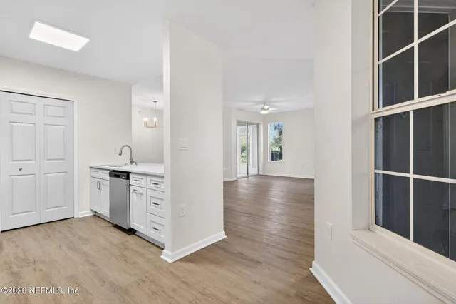a view of a kitchen with wooden floor and windows