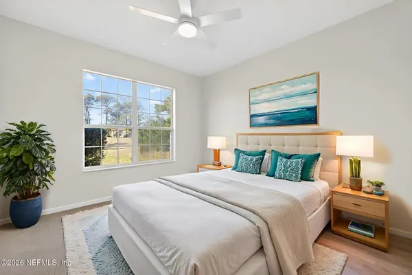a bedroom with a large bed and a potted plant