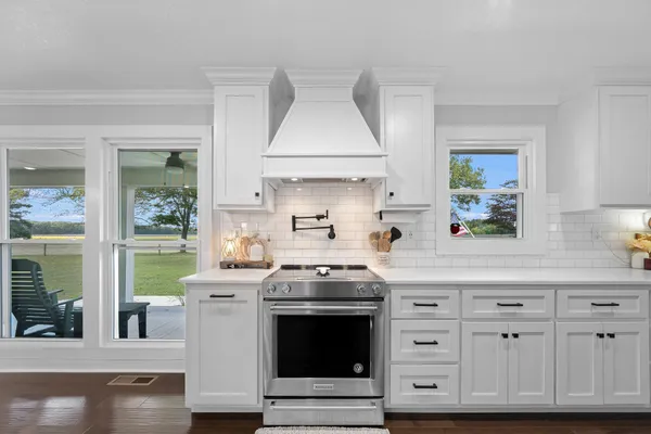 a bathroom with a toilet a sink a mirror a vanity and view of living room