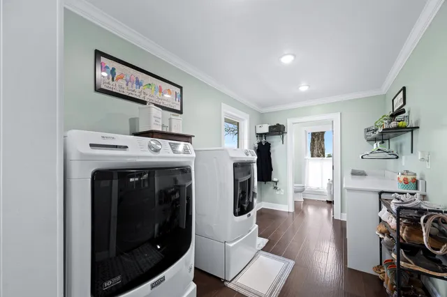 a bathroom with a toilet a sink a mirror a vanity and view of living room